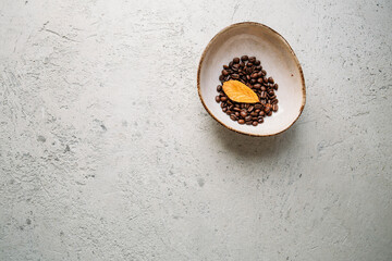 Autumn concept with coffee beans and yellow leaf on concrete background with copy space