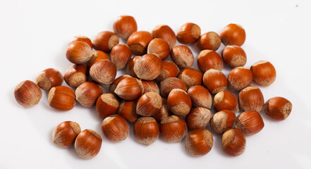 Heap of unshelled raw hazelnuts on white background. Natural healthy snack..