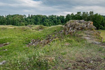 Fototapeta na wymiar Castle ruins abandoned in the infinite beauty of the expansive green. Rūjiena castle ruins.