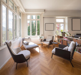 Living room area for conversation with armchairs and chaise longue. Bright windows overlooking the nature