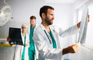 Portrait of young doctor checking X-Ray in hospital to make diagnosis