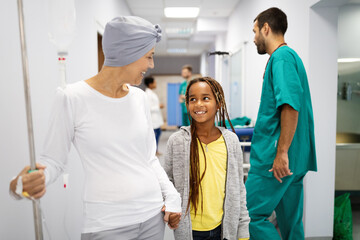 Sick woman with cancer hugging her young grandchild in hospital. Family support concept.