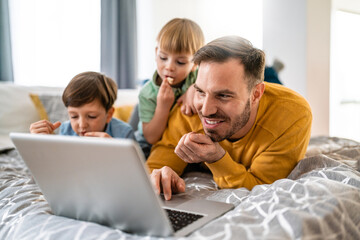Beautiful happy family with child looking at laptop with cheerful smile
