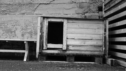 Wooden dog's house in Nybyen on the island Spitsbergen. Stone wall in the background