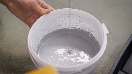The white paint is mixed in a bucket with a drill. Drill paddle mixer on a bucket with white paint, DIY tools and accessory, banner