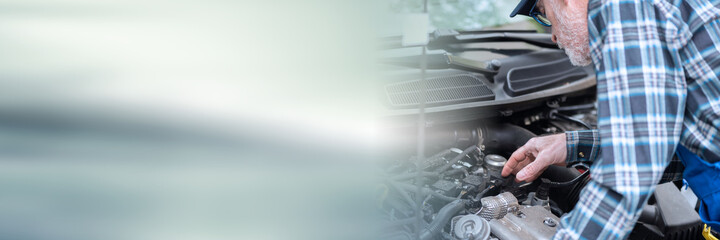 Car mechanic working on car engine; panoramic banner