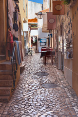 narrow cobbled street with small shops and cafes in the historic part of the Portuguese capital