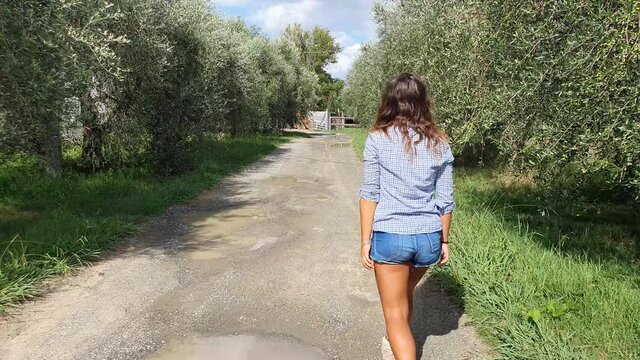 Ragazza cammina in una strada di campagna in slowmotion
