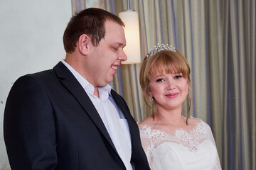 Bride and big fat groom in a nice room