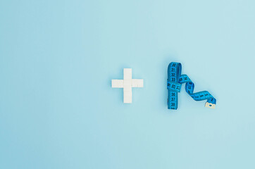 Obraz premium A centimeter for measuring a figure and a plus from sugar cubes.