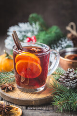 Christmas mulled red wine with spices and fruits on a wooden rustic table. Traditional hot drink at Christmas time