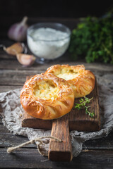 Fresh homemade open patties with cheese. Traditional Russian yeast pastry, round buns, curd tart. Buns with cottage cheese. Rustic style. Wooden background