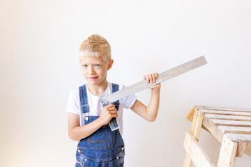 kid Builder construction keeps the line in front of a white wall, space for text, concept of construction and repair