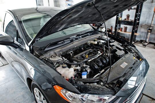 Car repair and maintenance theme. Car open hood engine in auto service.