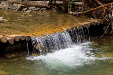 Small waterfall on wooden boards.