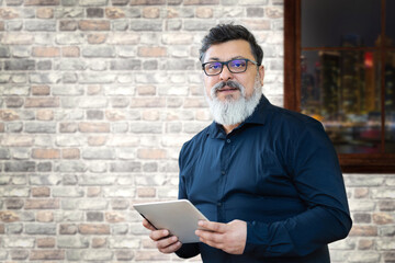 Portrait of modern mature middle eastern business man working late in office - 375085663