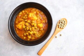 Indian popular homemade Aloo Matar. Potatoes and peas curry. Vatana batata bhaji or sabji. with cooking ingredients along with copy space. 