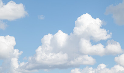 Naklejka na ściany i meble White cumulus clouds and cirrus clouds against the blue sky.