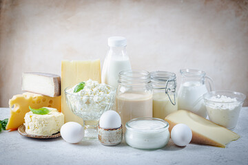 Fresh dairy products, milk, cottage cheese, eggs, yogurt, sour cream and butter on white table