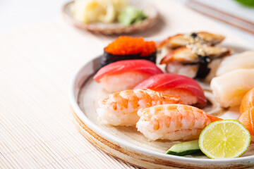 Set of sushi and maki on plate with soy sauce and chopsticks on white background. Top view with copy space
