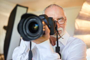 Professioneller älterer Fotograf als Porträtfotograf