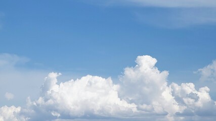 Naklejka na ściany i meble White cumulus clouds against the blue sky.