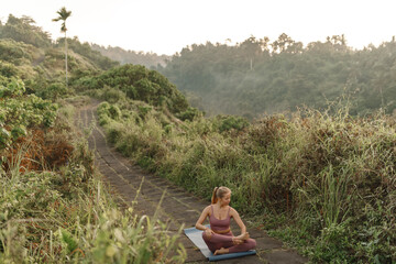 Young caucsian woman practicing yoga pose at the park ,  meditation have good benefits for health. Photo concept for Sport and Healthy lifestyle.