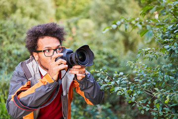 Junger Fotograf mit digitaler Kamera als Paparazzo
