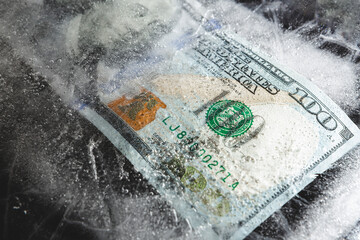 US dollars frozen under a layer of ice, the concept of the global financial crisis or the fall of the dollar in the world market