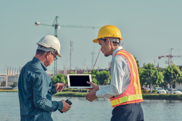 Two Asian man talking business construction project outdoor on site real estate,Project manager,project engineer
