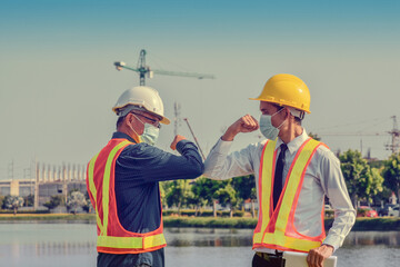 Engineers saluting each other by touching elbows,Two business people shake hand no touch outdoor on...