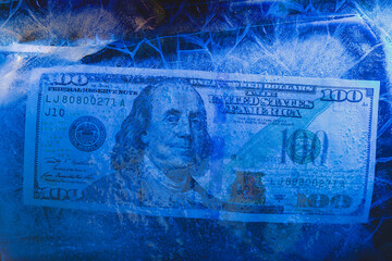 New $ 100 bill frozen under a layer of ice, the concept of the global financial crisis or the fall...