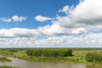 Fototapeta na wymiar Nature summer landscape, green field river, blue sky with clouds.