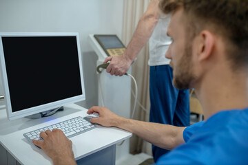 Bearded doctor checking results of exercise stress test on the screen