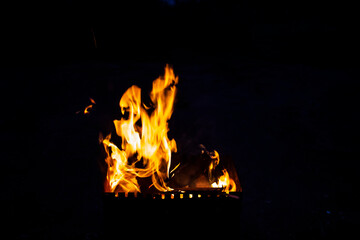 Fire on a dark background. Fire from firewood close up. Flaming burning sparks close-up, fire...