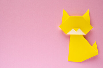 yellow origami cat on pink background
