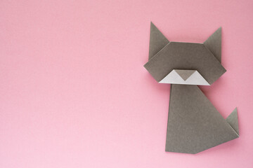 gray origami cat on pink background