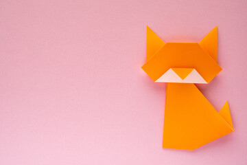 orange origami cat on pink background