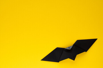 black origami bat on yellow background