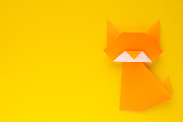 orange origami cat on yellow background