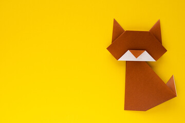 brown origami cat on yellow background