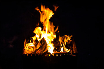 Fire on a dark background. Fire from firewood close up. Flaming burning sparks close-up, fire...