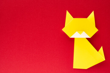 yellow origami cat on red background