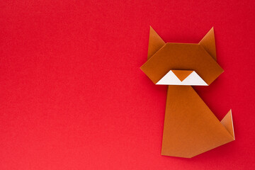 brown origami cat on red background