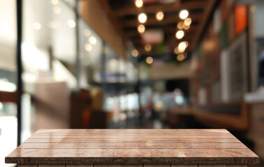 Empty wooden table top with lights bokeh on blur restaurant background