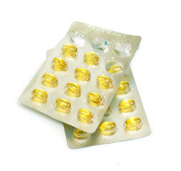 Medical yellow capsules of fish oil on a white background.