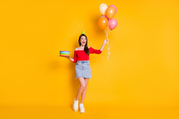 Fototapeta premium Full length photo of positive cheerful girl enjoy anniversary party occasion hold many balloons birthday bright cake wear off-shoulder top legs isolated over shine color background