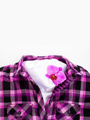 Fashion concept. Purple checkered shirt and pink orchid. Top view.