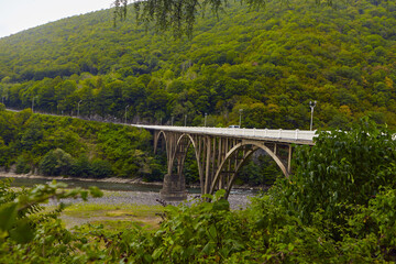 The mountain river along the Road, of a scenic highway by the beautiful Landscape covered in clouds and fog, bridge and viaduct, The mountain river along the road,