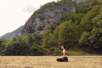 Yoga classes in nature. The concept of playing sports alone. Social exclusion. A woman does yoga in...